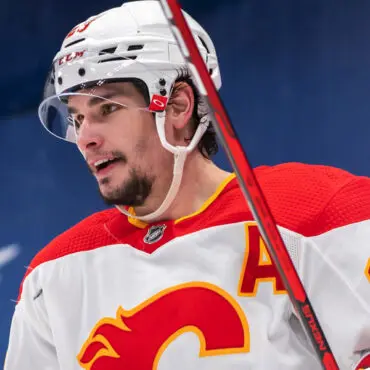 Hockey player in Calgary Flames uniform on the ice.