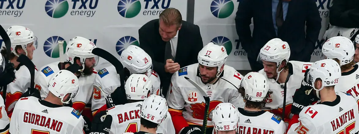 Hockey coach strategizing with players during a timeout.