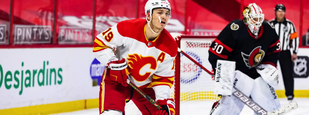 Hockey player in Calgary Flames uniform on ice during a game.
