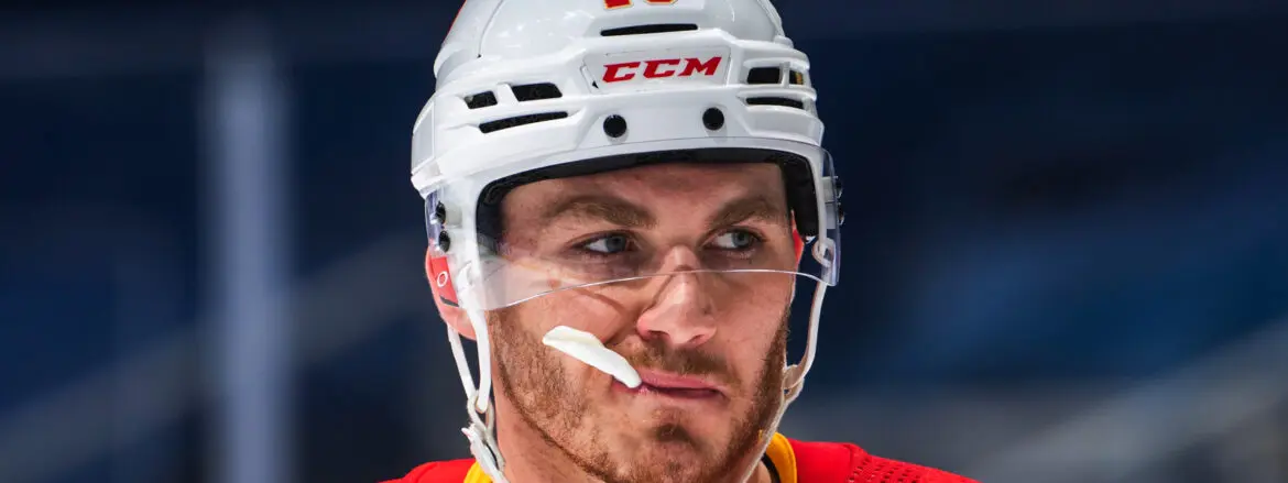 Close-up of a focused hockey player wearing a white CCM helmet.