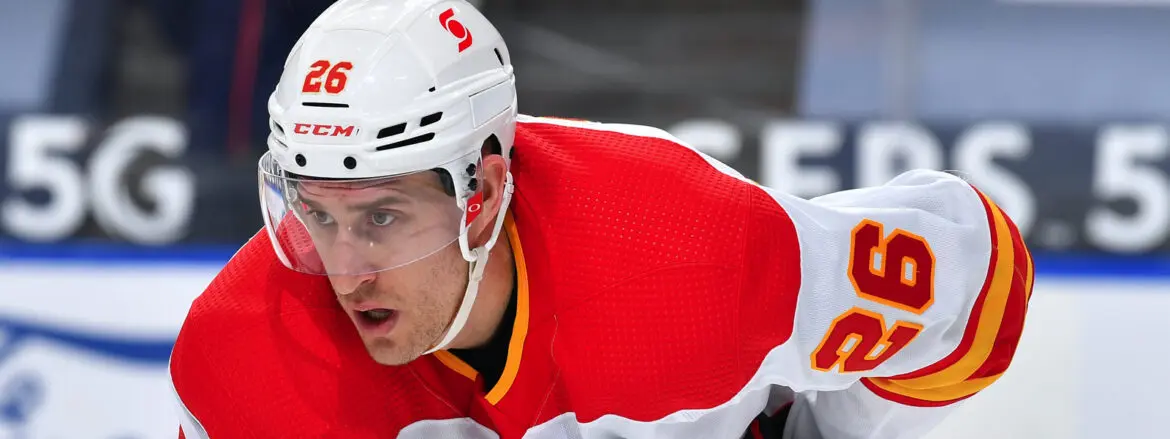 Focused ice hockey player in red and white gear.