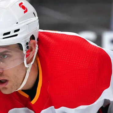 Focused ice hockey player in red and white gear.