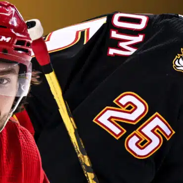 Close-up of a hockey player in red with a black jersey showing number 25.