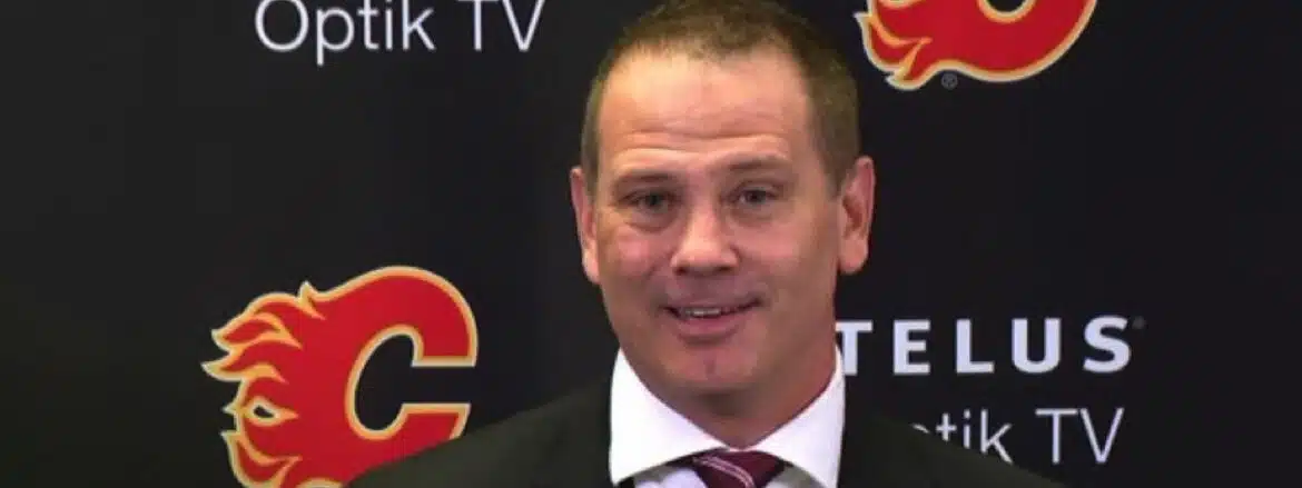 Man in a suit and tie smiling at the camera.