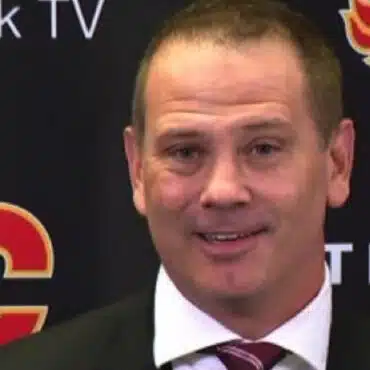 Man in a suit and tie smiling at the camera.