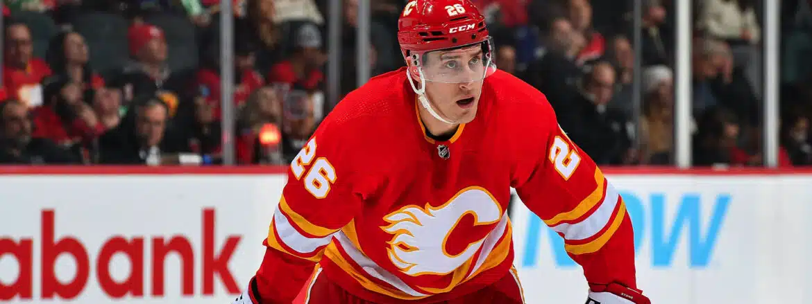 Hockey player in red Calgary Flames jersey focused during a game.