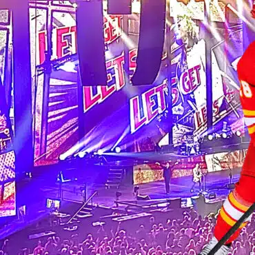 Ice hockey player skating near the goal in a packed arena.