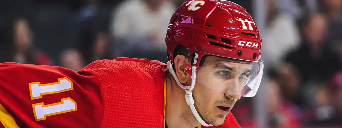 Close-up of a hockey player wearing a red helmet and jersey.