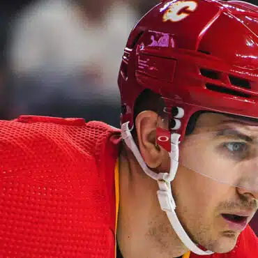 Close-up of a hockey player wearing a red helmet and jersey.