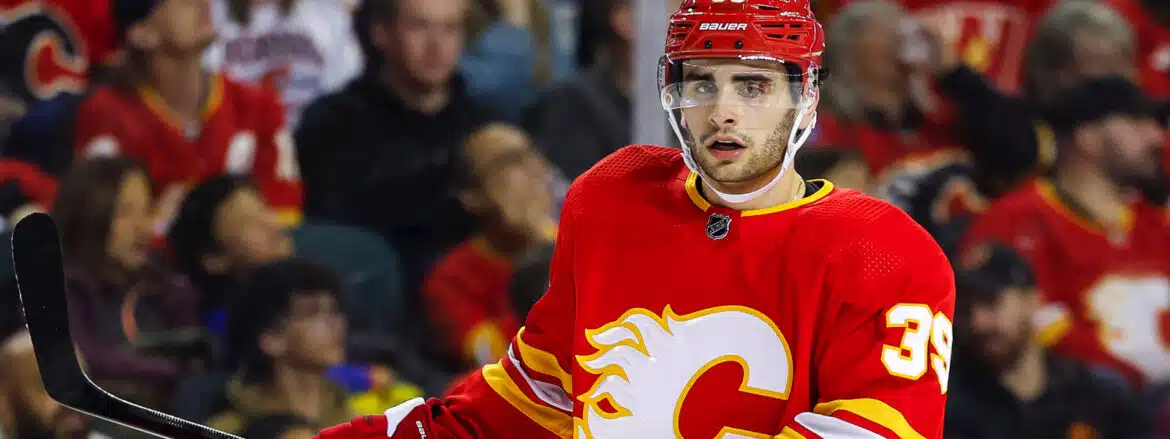 Hockey player in red Calgary Flames jersey on ice rink.