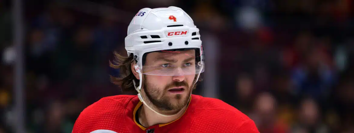 Close-up of a hockey player in a white helmet and red jersey.