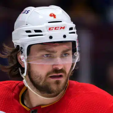 Close-up of a hockey player in a white helmet and red jersey.