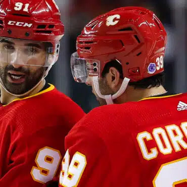 Two Calgary Flames hockey players in red jerseys during a game.