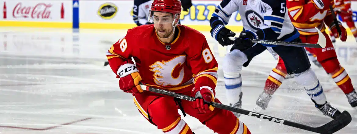 Hockey player in red Calgary Flames uniform skating on ice.