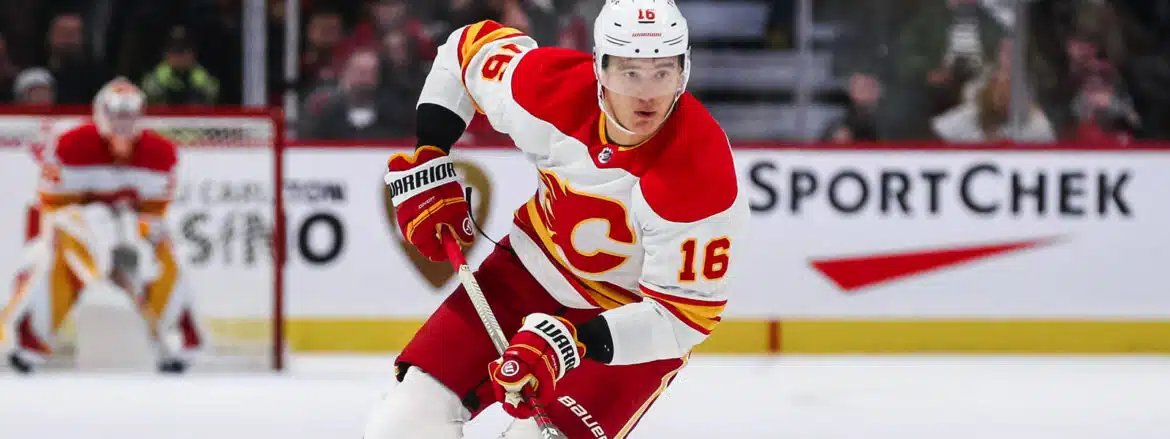 Hockey player in Calgary Flames uniform skating on ice.