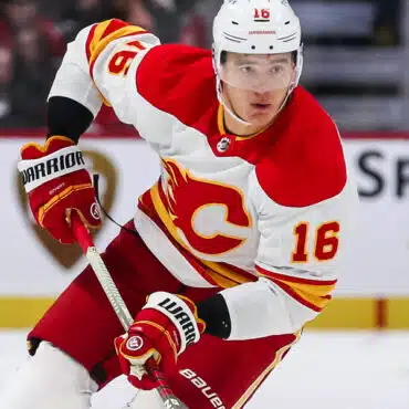 Hockey player in Calgary Flames uniform skating on ice.