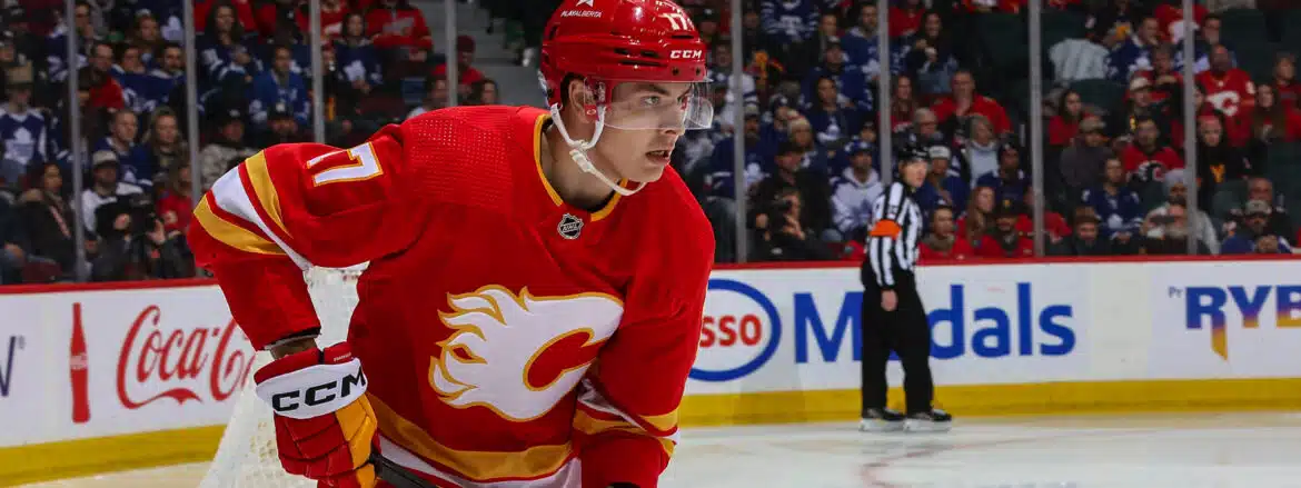 Hockey player in red Calgary Flames jersey during a game.