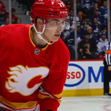 Hockey player in red Calgary Flames jersey during a game.