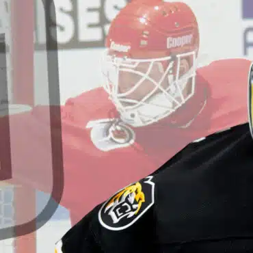 Ice hockey goalie in red gear and a security officer in black uniform.
