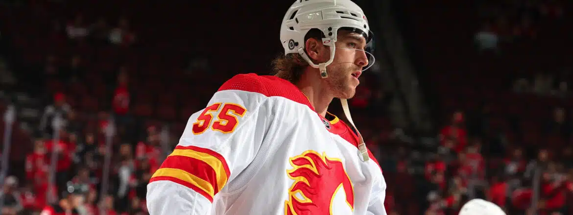 Hockey player in Calgary Flames jersey on ice.