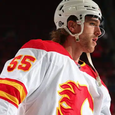 Hockey player in Calgary Flames jersey on ice.