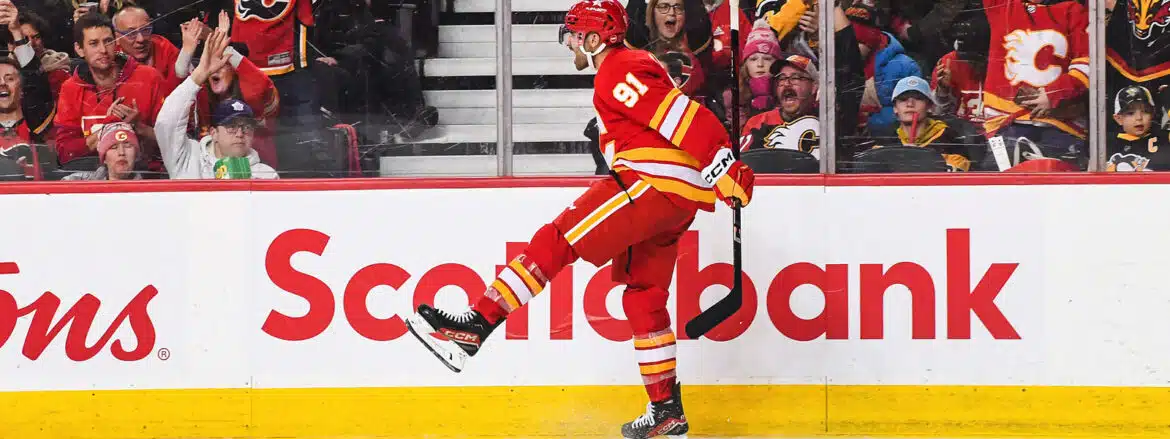 Hockey player in red uniform celebrates a goal on the ice rink.