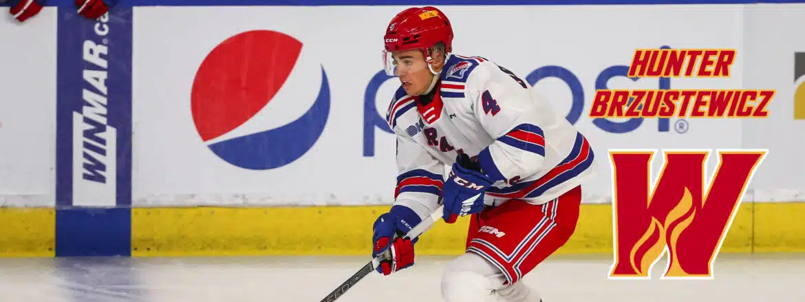Hockey player in red and blue uniform skating on ice.