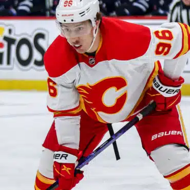 Hockey player in red and white Calgary Flames uniform on ice.