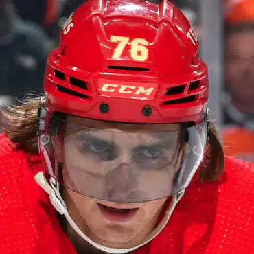 Close-up of a hockey player wearing a red helmet with number 76.