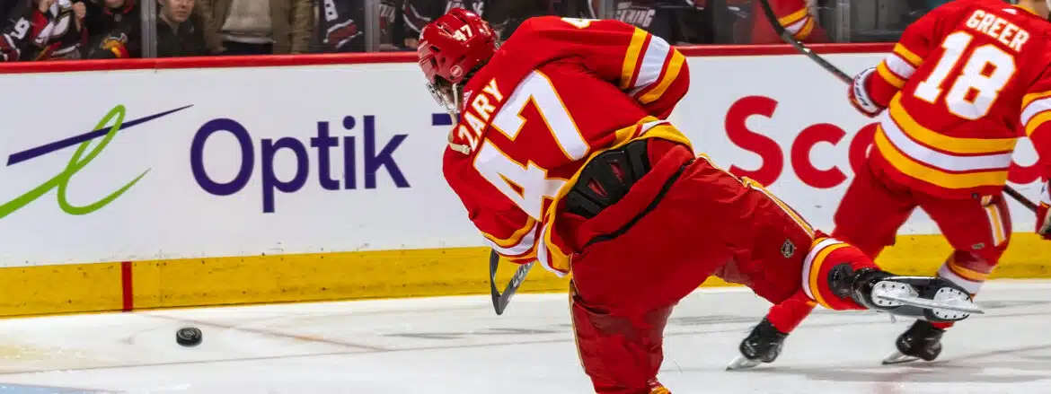 Hockey player in red jersey skating on ice rink during a game.