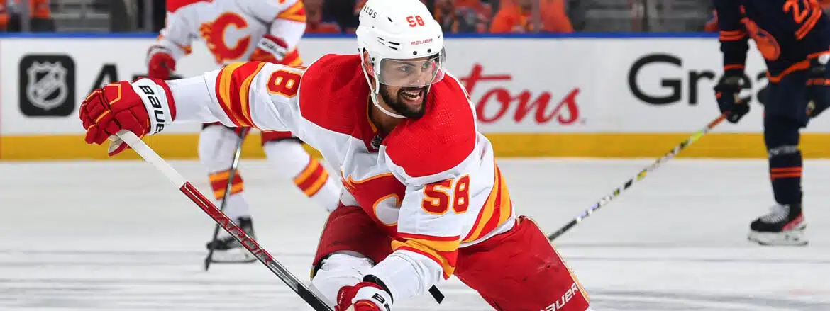 Ice hockey player in red and white uniform skating intensely.