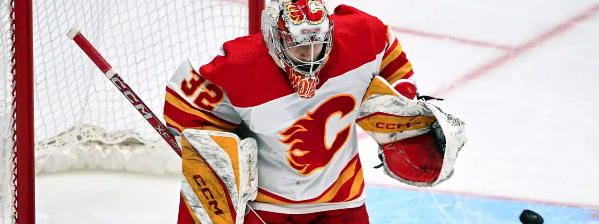 A Calgary Flames goalie in action during a hockey game.