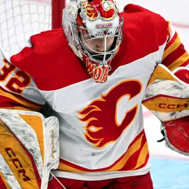 A Calgary Flames goalie in action during a hockey game.