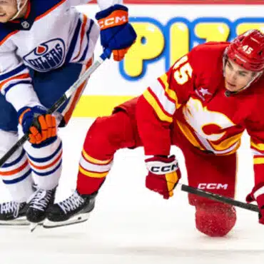 Two hockey players competing intensely on the ice rink.