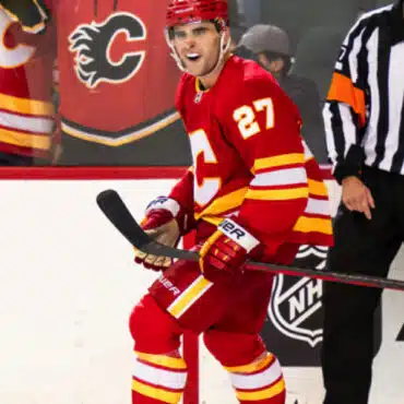 Hockey player in red Calgary Flames uniform on ice.