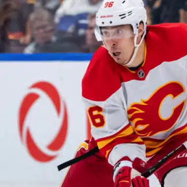 Ice hockey player in Calgary Flames uniform skating during a game.