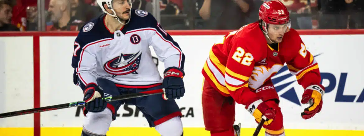 Two hockey players from opposing teams in action on the ice rink.