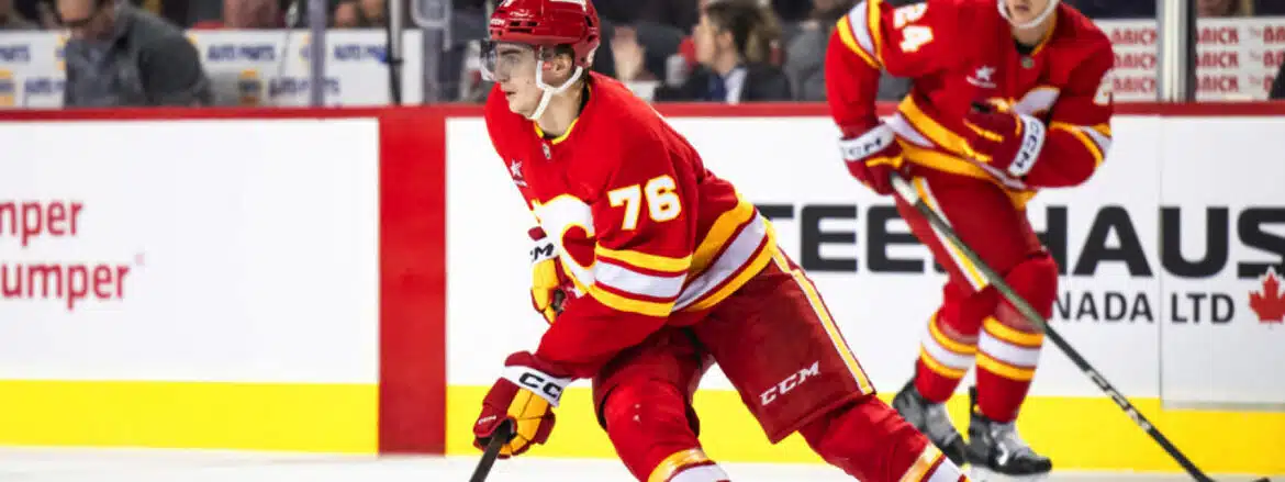 Hockey player in red and yellow uniform skating on ice during a game.