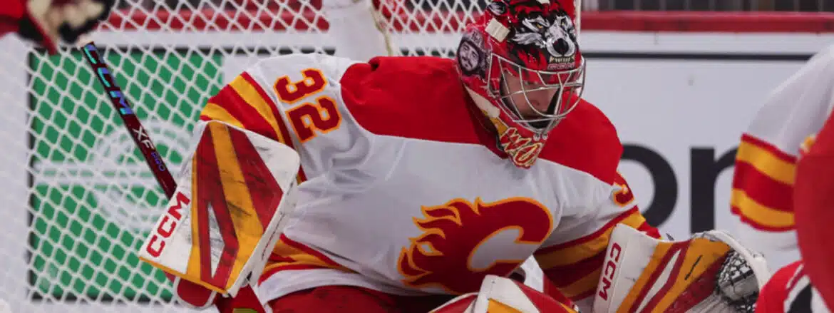 Hockey goalie in Calgary Flames uniform ready to defend the net.