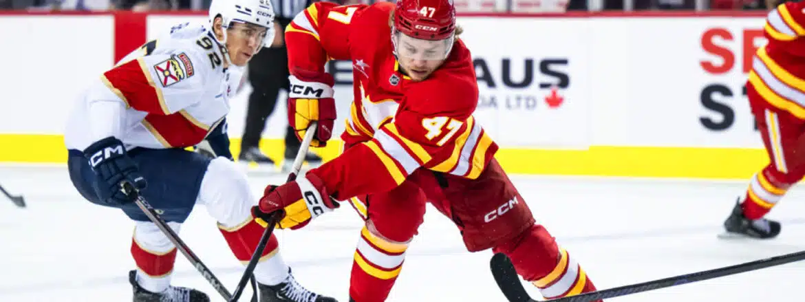 Ice hockey player in red jersey skating fast on the rink.