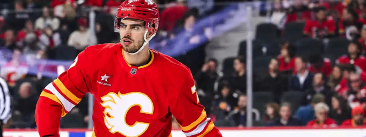 Hockey player in red Calgary Flames uniform on ice rink.