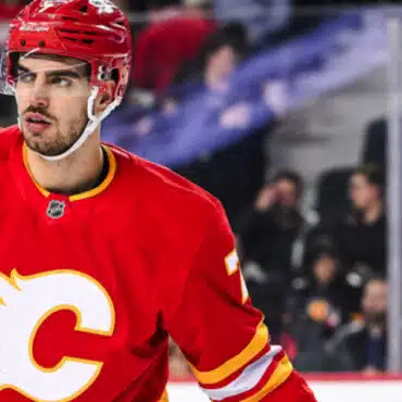 Hockey player in red Calgary Flames uniform on ice rink.