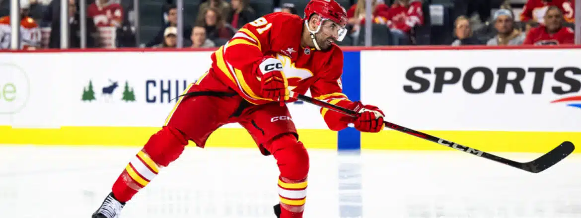 Hockey player in red uniform skating on ice during a game.
