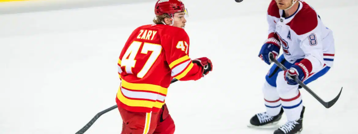 Ice hockey player in red jersey with number 47 skating on ice.