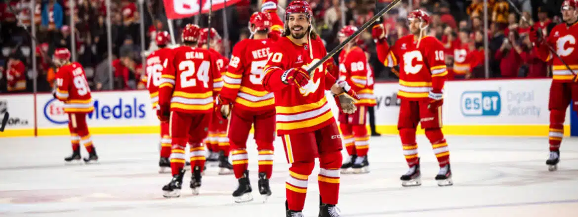 Calgary Flames celebrate a goal on ice during a hockey game.