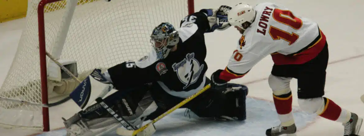 Ice hockey goalie making a save during a game.