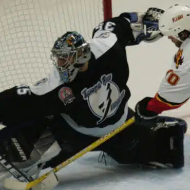 Ice hockey goalie making a save during a game.