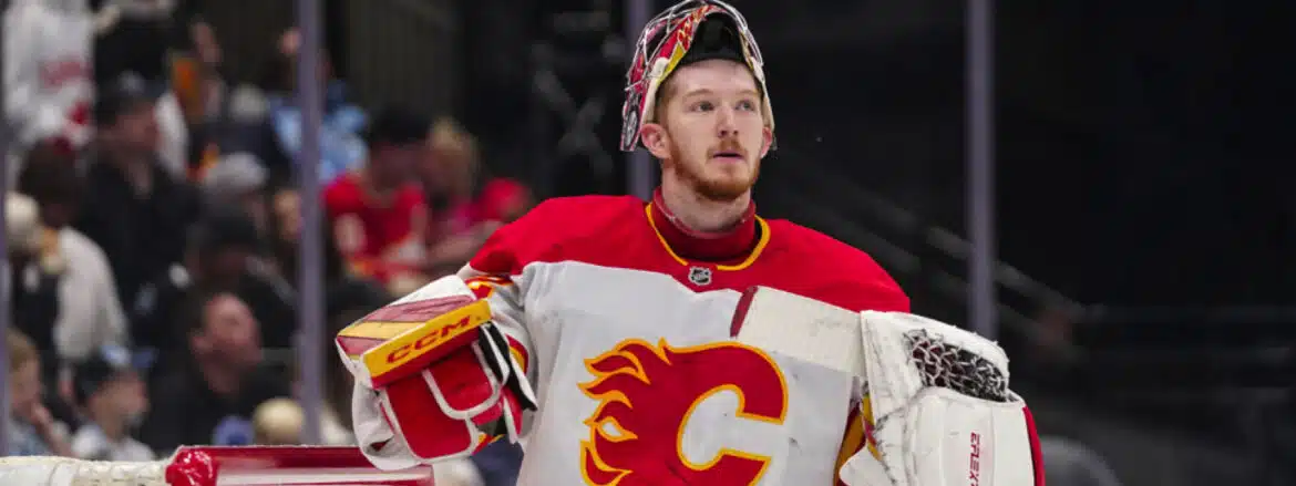 Hockey goalie in Calgary Flames jersey during a game.