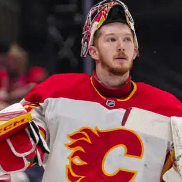 Hockey goalie in Calgary Flames jersey during a game.