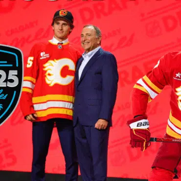 Young hockey player in Calgary Flames jersey with an official at the NHL draft.